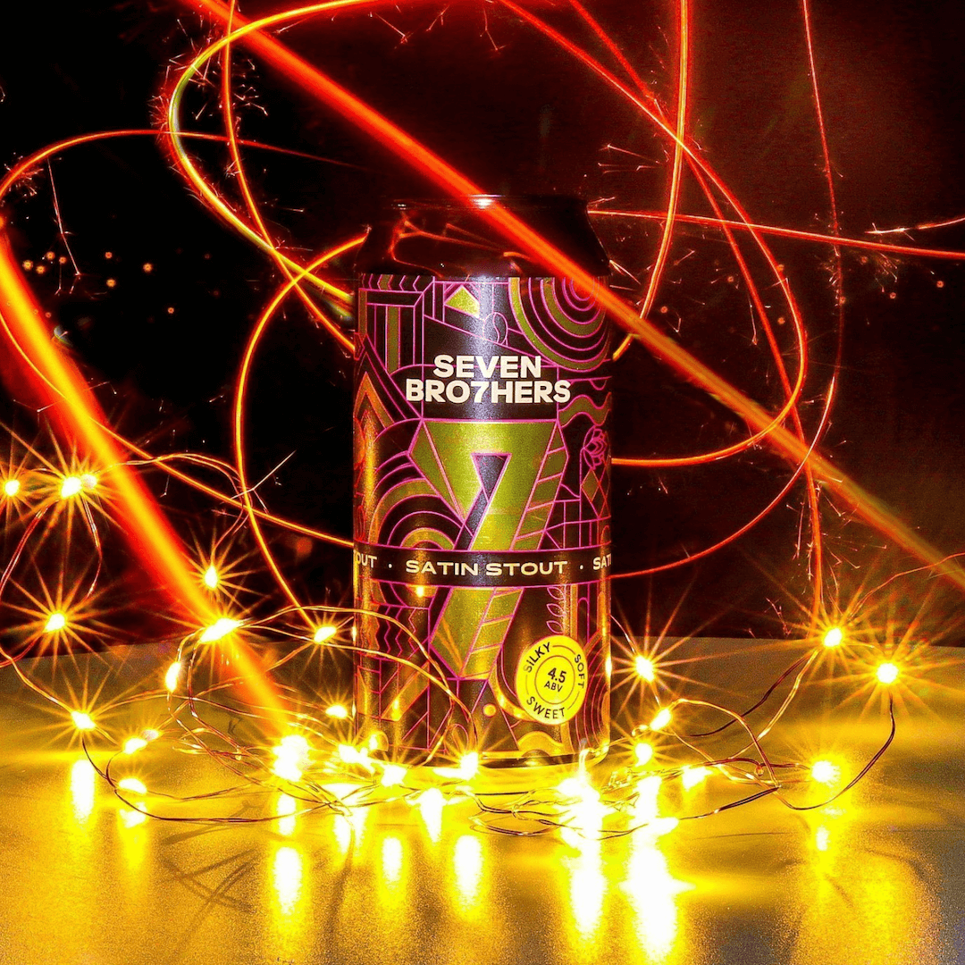 Seven Brothers Satin Stout can surrounded by colourful lights on a dark background.